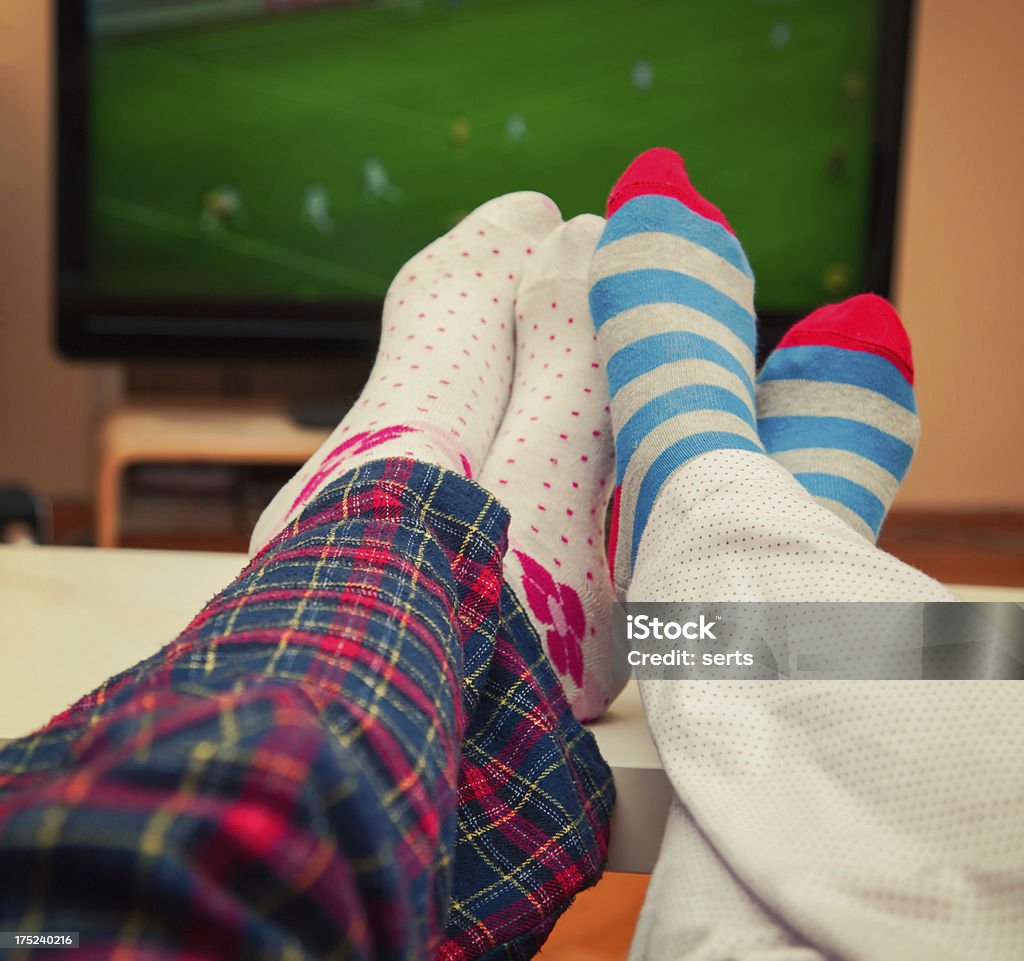 Watching TV two friend watching footbal match on TV in sunday. Television Set Stock Photo