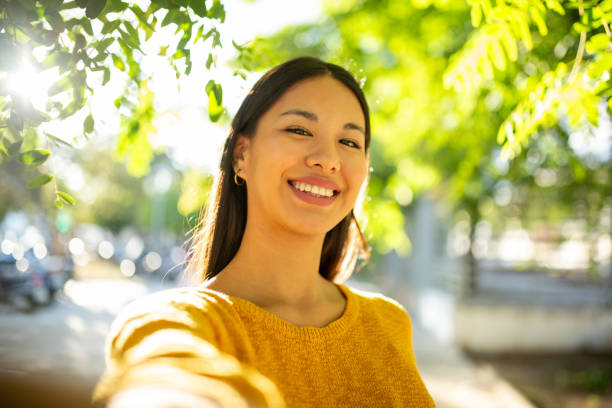 istock smiling young woman taking selfie in park 1752410501