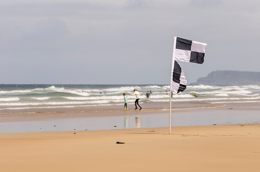 Black and white chequered surfers flag warning swimmers that surfers and kayaks are in the area
