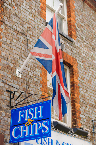 British Union Jack flying above a sign for a Fish and Chip shop