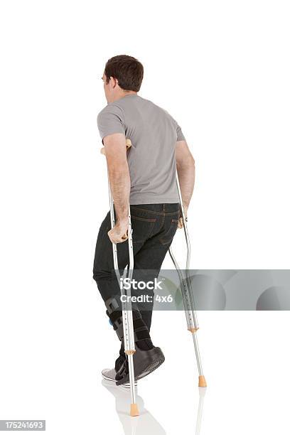 Heridas Hombre Caminando Con La Ayuda De Crutches Foto de stock y más banco de imágenes de 20 a 29 años - 20 a 29 años, Adulto, Adulto joven