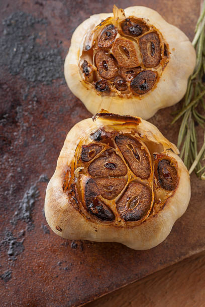 жареный чеснок с тимьян на каменный вертикальные - roast garlic стоковые фото и изображения