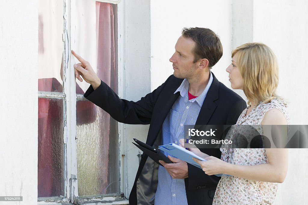 Renovation, looking at old window, examining "Real estate agent in front of building, renovation" Restoring Stock Photo
