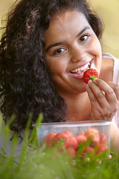 istock Pretty Young Woman Outdoors Eating Strawberries 175242309