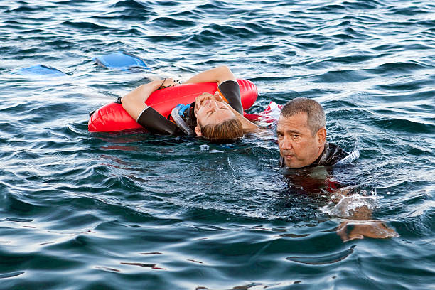 Life Saver man rescue to the woman "Adult Caucasian. Focus on man's face.Facial expression ;Man is serious, woman is fell bad, she had pain." drowning photos stock pictures, royalty-free photos & images