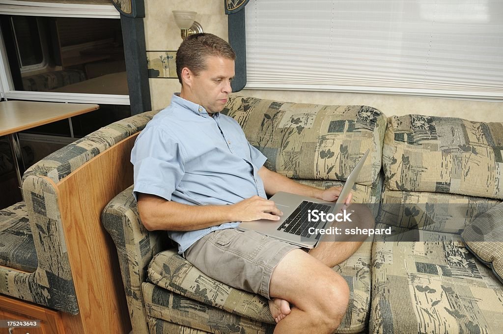 Hombre usando computadora portátil en vehículos recreativos - Foto de stock de Actividades recreativas libre de derechos