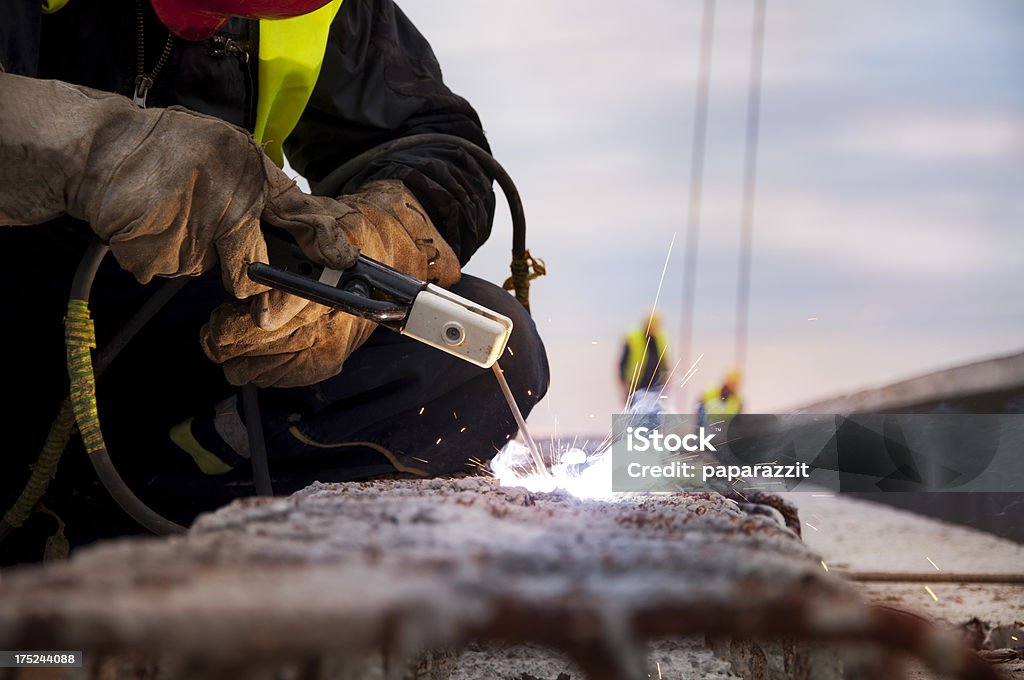 Welder on a construction site Welder on a construction site doing some welding outside Adult Stock Photo