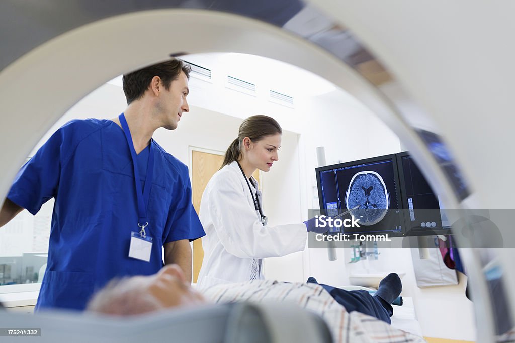 Two Doctors with Patient at CAT Scan Two Doctors with Patient at CAT Scan. Slight motion blur. MRI Scan Stock Photo