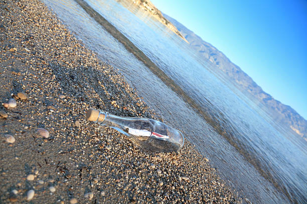 sos mensaje en una botella - correspondence waving horizontal outdoors fotografías e imágenes de stock