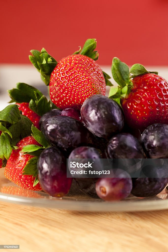 Fresas y uvas en una mesa en la cocina doméstica - Foto de stock de Alimento libre de derechos