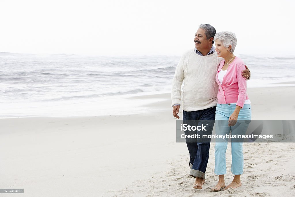Senior Couple Walking Along Beach Together Senior Couple Walking Along Beach Together Smiling Latin American and Hispanic Ethnicity Stock Photo