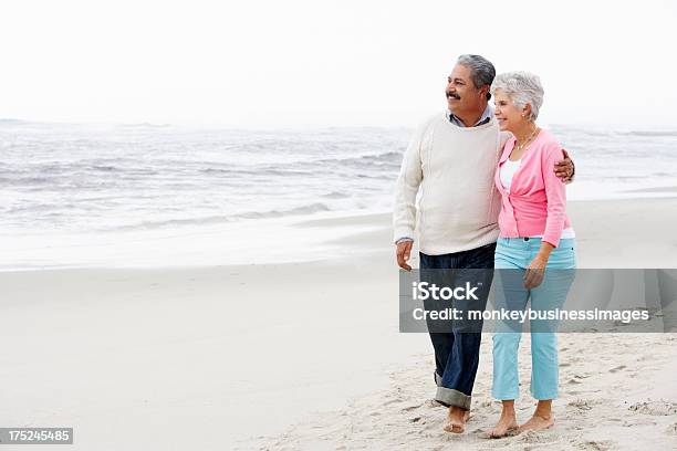 Senior Couple Walking Along Beach Together Stock Photo - Download Image Now - Latin American and Hispanic Ethnicity, Senior Couple, Senior Adult