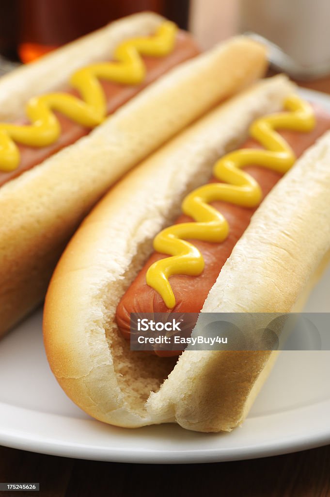 Hot dogs "Two hot dogs with mustard in a white plate, selective focus. More hot dogs..." Hot Dog Stock Photo