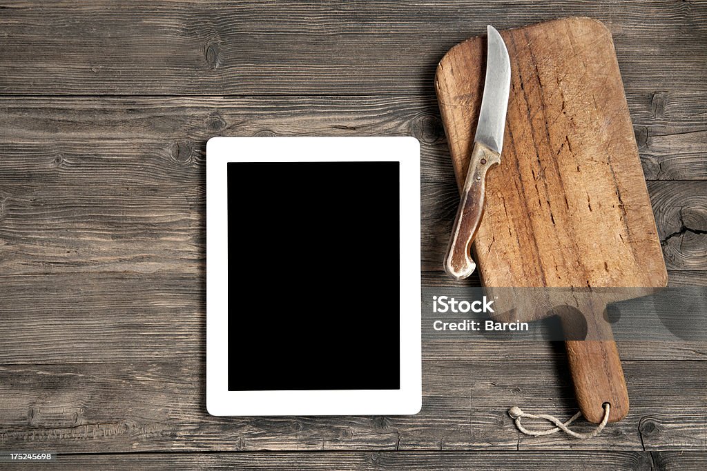 Vieja tabla de cortar con tableta digital - Foto de stock de Alimento libre de derechos