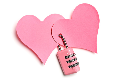 Two heart shaped notes locked by padlock on white
