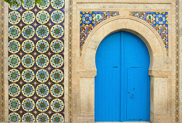 Exterior of a colorful building with a blue door in Tunisia stock photo