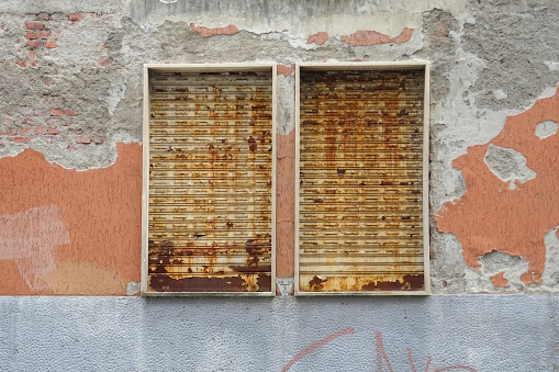 windows with rusty metal shutters, old building to be completely renovated