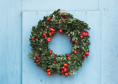 Christmas wreath on blue wooden background. Top view with copy space