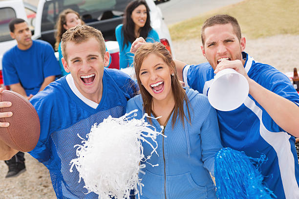 Excited group of sports fans cheering outside football stadium Excited group of sports fans cheering outside football stadium. cheerleader photos stock pictures, royalty-free photos & images