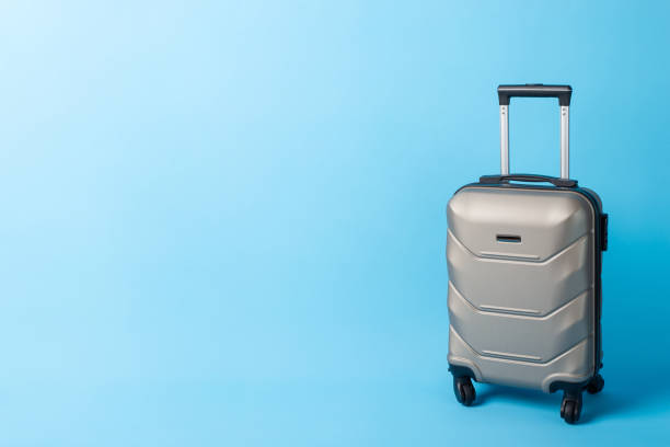 istock Pack and Go: A chic travel suitcase photographed from the side view on a blue surface, ready for your text or promotional content 1752468908