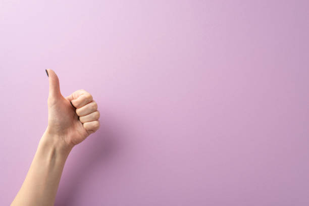 istock From a first-person top view perspective, my hand, embellished with a chic black manicure, crafts a thumbs-up gesture against lilac surroundings. Ample area for text or advertisements is available 1752470592