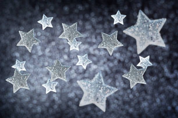 istock Silver shiny christmas baubles in star shape with sparkling sequins on blurred dark black background with defocus lights 1752473517