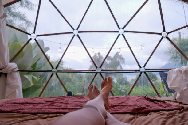 Unrecognizable Woman Legs Crossed at Ankle Lying on bed inside dome tent Close-up shot of Unrecognizable Woman Legs Crossed at Ankle Lying on bed inside dome tent staycation hotel asian stock pictures, royalty-free photos & images