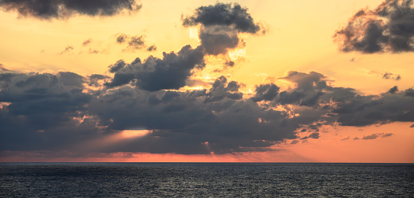 A fiery, dramatic sky over the open sea.