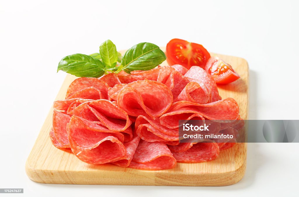 Salame italiano fatiado sobre uma tábua de corte - Foto de stock de Alimentos Defumados royalty-free
