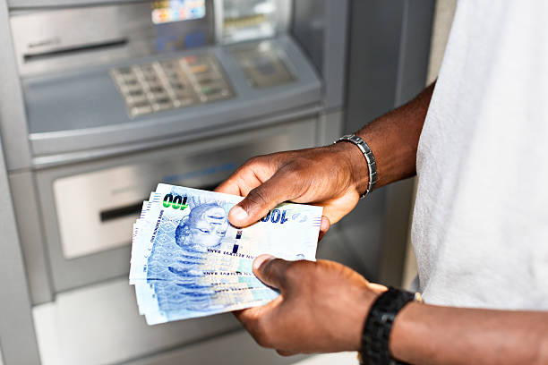 macho mãos segurando o dinheiro no caixa eletrônico-sul-africano - currency spending money african descent black - fotografias e filmes do acervo