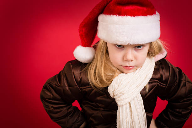 bambina intrattabile che indossa cappello da babbo natale con sfondo rosso - impatient children only child anger foto e immagini stock