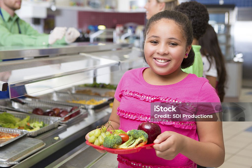 Engraçado Criança de escola primária Menina escolher alimentos saudáveis na escola Cantina - Royalty-free Merenda Escolar Foto de stock