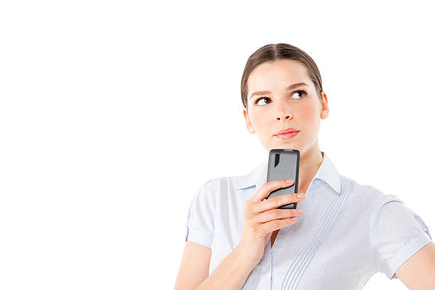 istock Beautiful executive with a cell phone looking away thinking 175250769