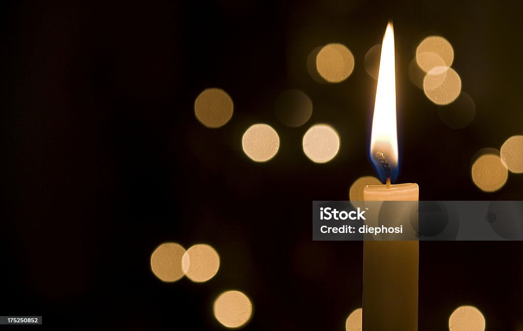 Points of light in the darkness a single candle lit at night and in the background are light reflections Candle Stock Photo