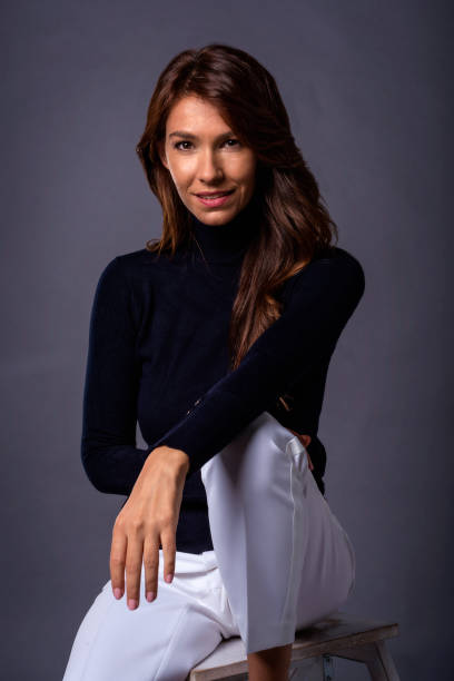 istock Attractive brunette haired female wearing black turtleneck sweater against grey background 1752510937