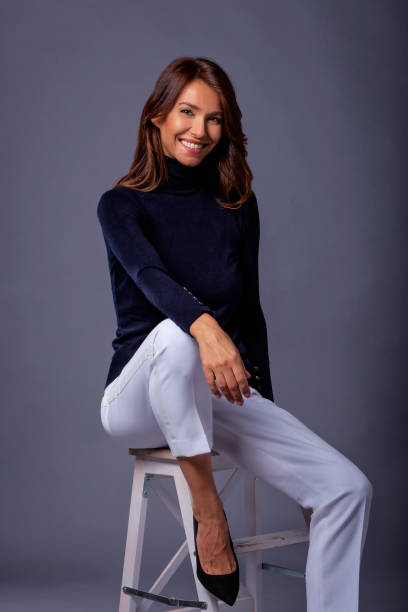 istock Attractive brunette haired woman sitting against grey background 1752510942