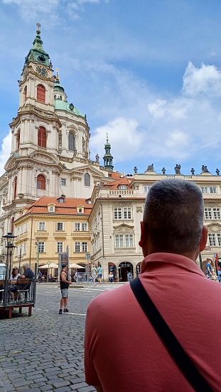 Prague, Czech Republic - June 9, 2023: Old man enjoying sightseeing in Lesser town, Prague city.