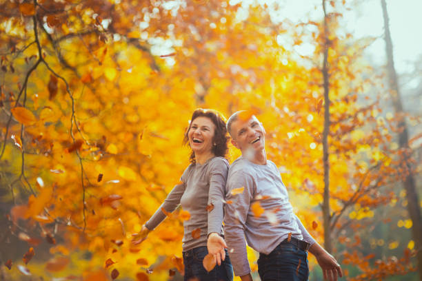 istock cheerful boyfriend and girlfriend in park throwing autumn leafs 1752521037