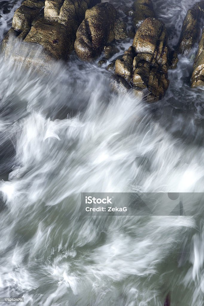 Forza d'acqua contro le rocce sulla spiaggia - Foto stock royalty-free di Acqua