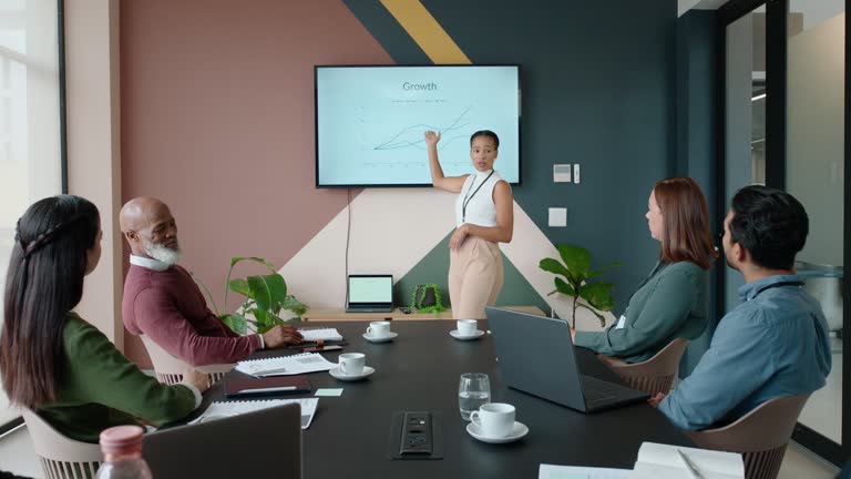 Business people, conference room and growth on screen with presentation, communication and meeting. Information, market statistics and black woman speaker with graph, seminar and discussion with team