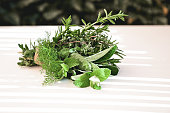 Various fresh herbs on a table outdoors.