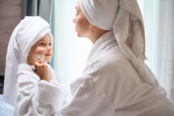 istock Mother watching her little daughter applying blush on her cheek 1752539955