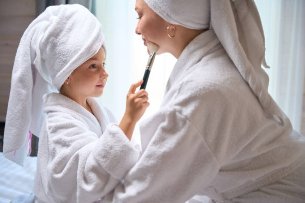 istock Pretty little daughter applying blush on mother face 1752539964