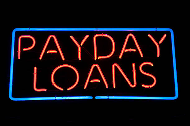 payday займов сообщение неоновый знак в красны�й - wages loan loan shark neon light стоковые фото и изображения
