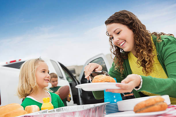 Kids and adults tailgating; cooking out at college football stadium Kids and adults tailgating; cooking out at college football stadium. people family tailgate party outdoors stock pictures, royalty-free photos & images