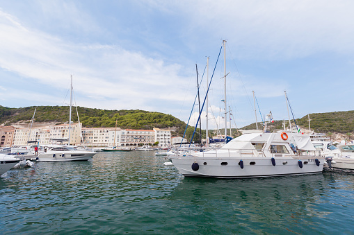 Bonifacio, France - August 22, 2018: Pleasure motor boats and sailing yachts with ordinary people. Marina of Bonifacio, small port city of Corsica island