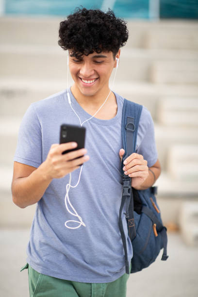 istock smiling handsome man with bag looking at cellphone 1752553541