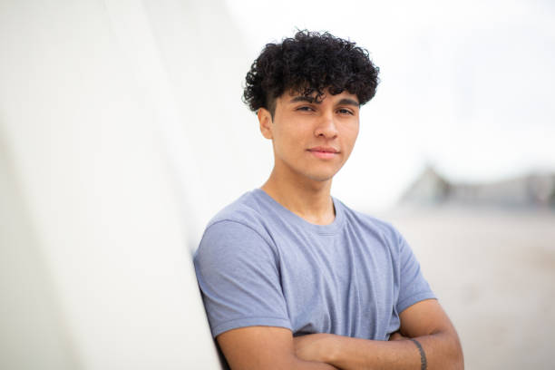 istock serious young man leaning against wall with arms crossed 1752554127