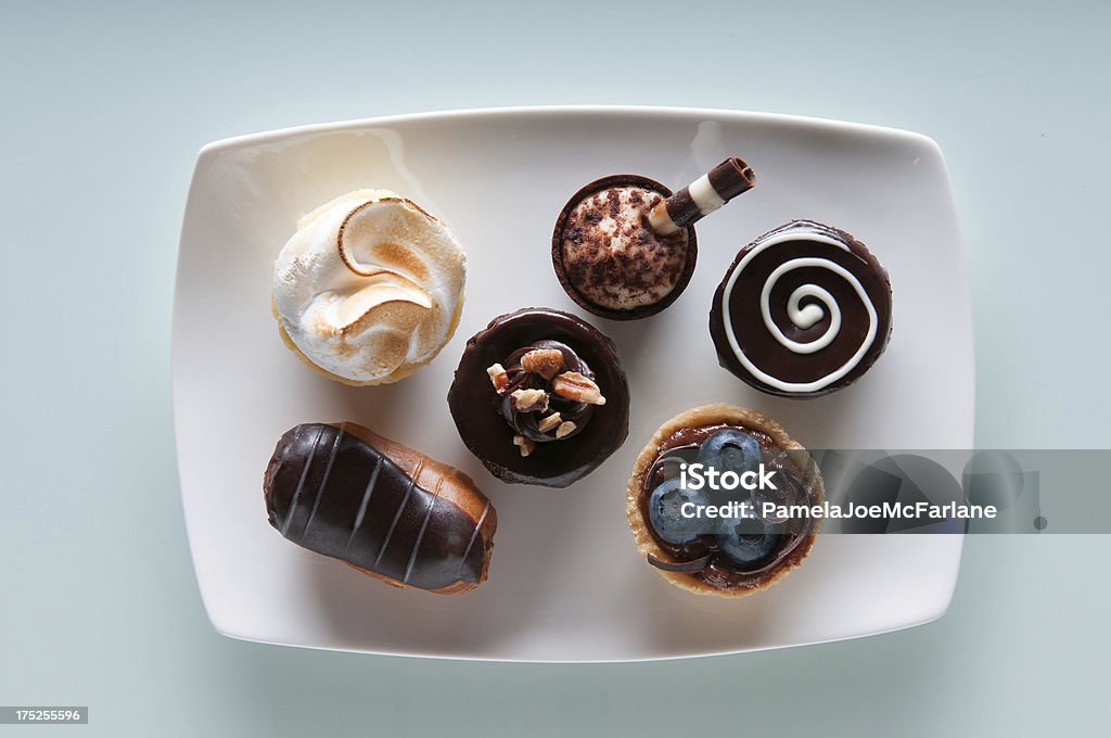 Assortment of Mini Desserts . "A selection of mini desserts arranged on a white plate.  Clockwise from top left: lemon meringue, tiramisu, brownie, blueberry chocolate mousse, brownie with nuts, and chocolateMore desserts on blue backgrounds:" Dessert - Sweet Food Stock Photo