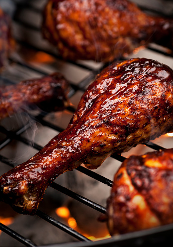 Chicken legs on the grill with barbecue sauce.  Please see my portfolio for other food related images. 